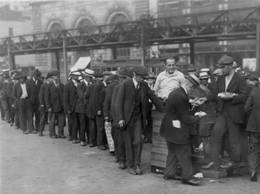 Men lined up in a breadline in NY City waiting for food.