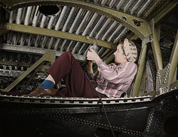 A woman riveting a plane